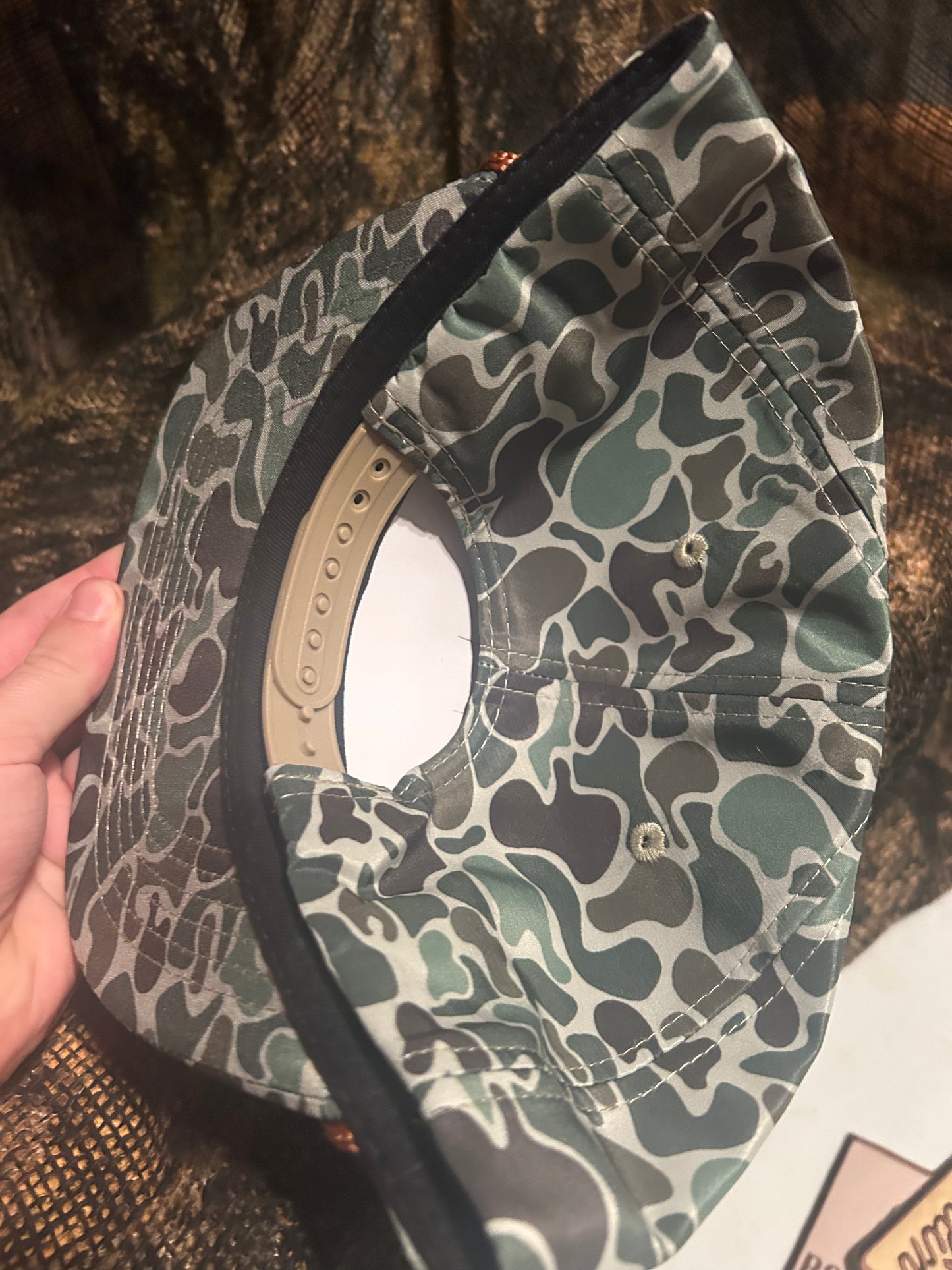 Remington First in the Field patch on a jungle camo ropebrim SnapBack hat