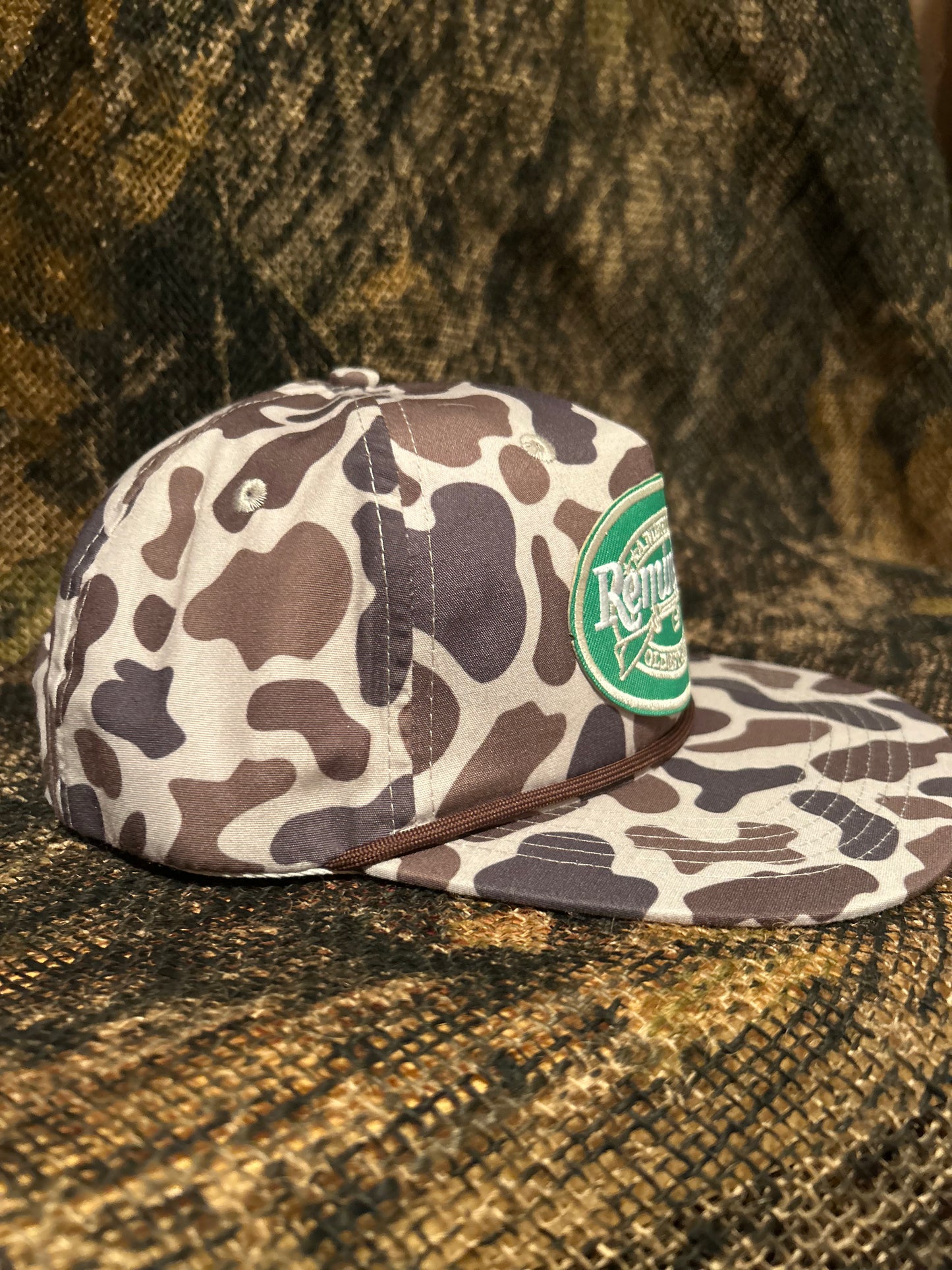 Remington patch on brown Camo ropebrim SnapBack hat