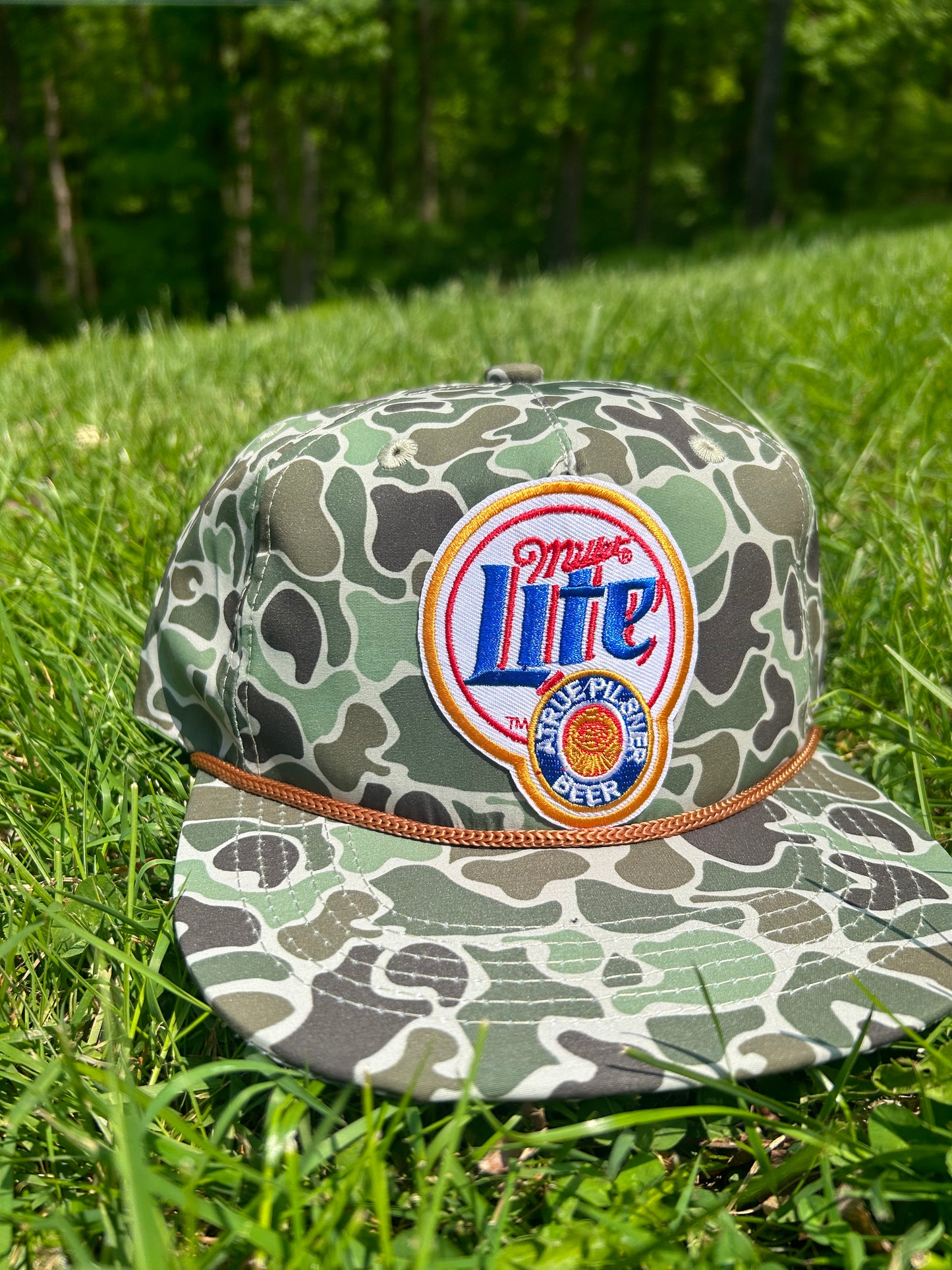 Miller lite patch on a jungle Camo ropebrim SnapBack hat