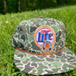 Miller lite patch on a jungle Camo ropebrim SnapBack hat